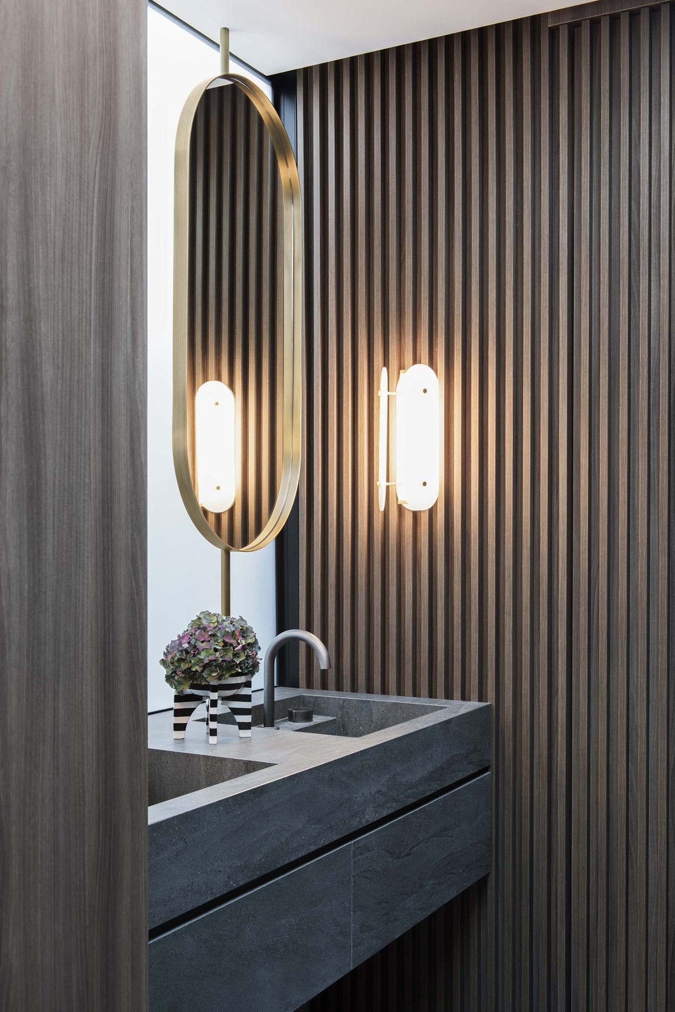 Modern minimalist bathroom with solid surface vanity sink and walnut wood wall panels