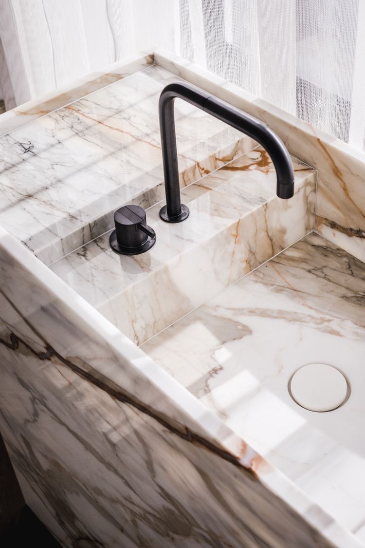 Modern marble sink with integrated countertop and matte black faucet