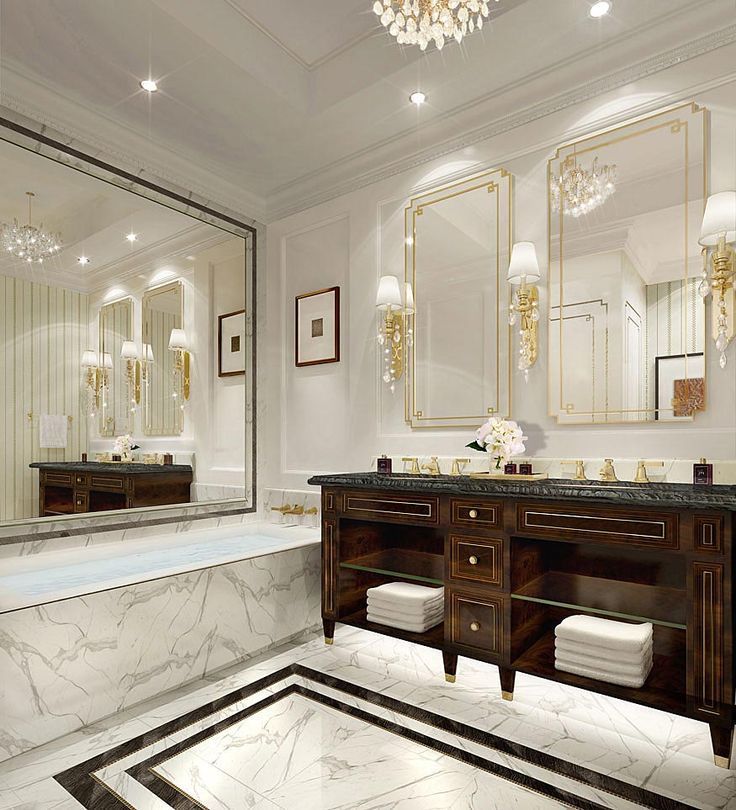 Grand classic luxury bathroom featuring a stunning white marble-clad built-in bathtub and a dark wood double bathroom cabinet topped with a black marble countertop, complemented by ornate gold-framed mirrors, crystal wall sconces, and a chandelier, creating a timeless and opulent ambiance.