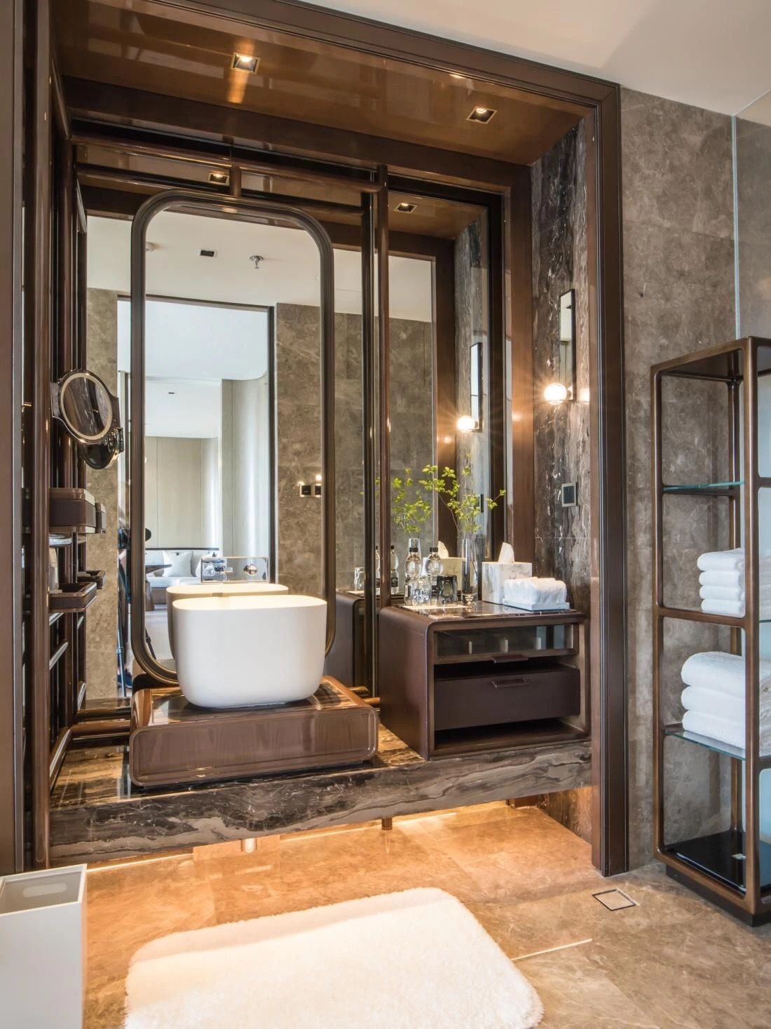 Custom bathroom vanity design with dark stone countertop, white vessel sink, and arched mirror in a luxury bathroom.
