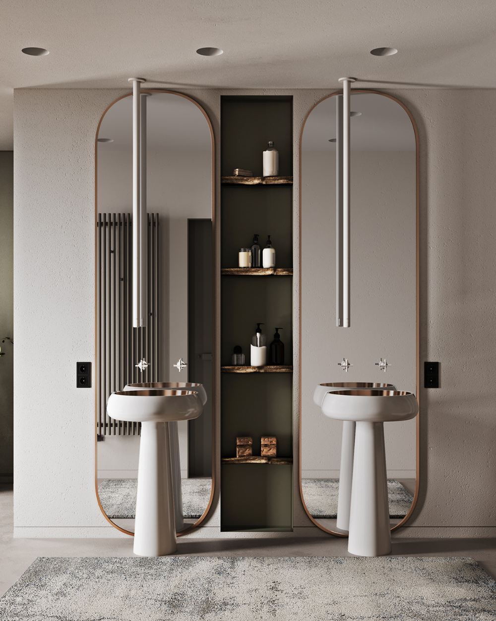 A modern luxury bathroom with twin white freestanding pedestal sinks featuring metallic basins, tall oval mirrors with central vertical lights, and a dark green central shelving niche against light grey walls.