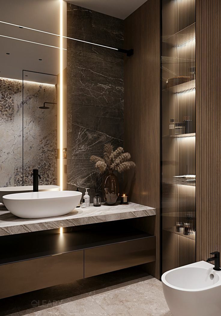 In a modern luxury bathroom, a white matte countertop basin with a black faucet sits atop a marble countertop on a dark wood grain floating vanity, with LED lighting and a tall wooden cabinet in the background.