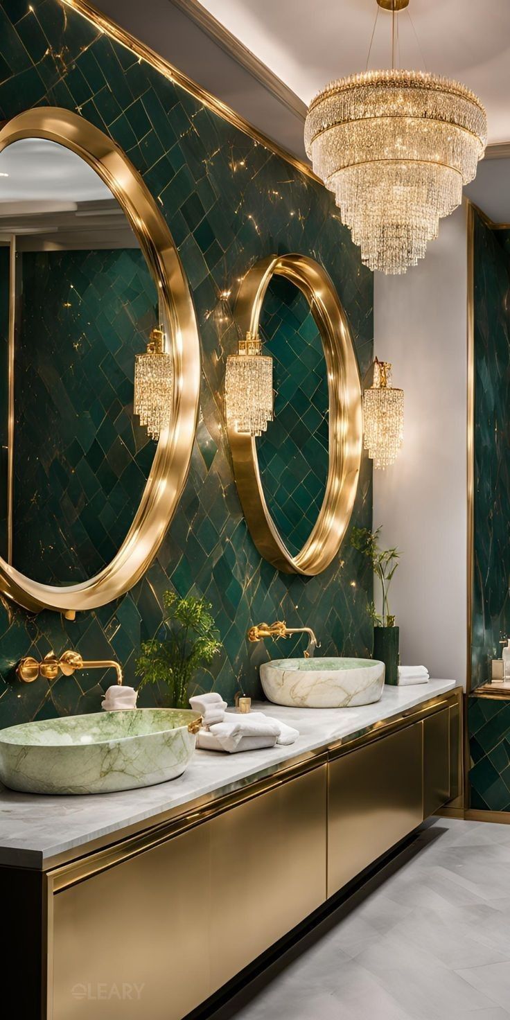 An opulent green and gold luxury bathroom featuring a brass bathroom vanity, green marble vessel sinks, and large, round gold mirrors under a sparkling crystal chandelier.