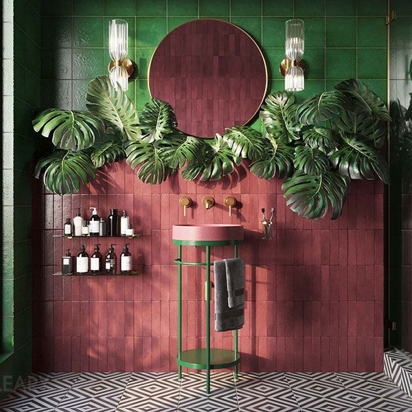 A lush, atmospheric bathroom with emerald green and dusky pink tiles, featuring a minimalist green and pink pedestal sink, a large round tinted mirror, and abundant Monstera leaves.