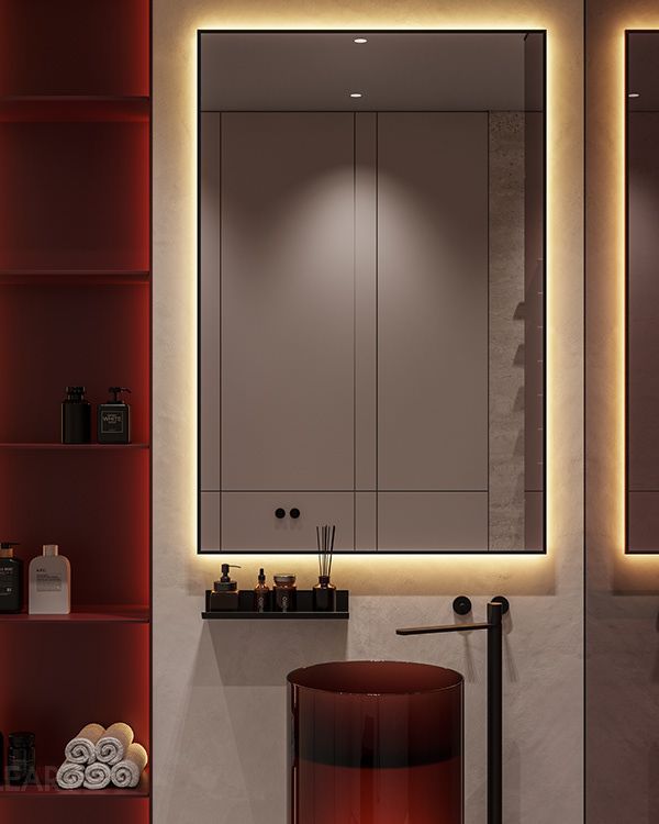 A modern minimalist bathroom featuring a bold, deep red resin pedestal sink, a floor-mounted matte black faucet, and a large backlit mirror against a microcement wall, with coordinating red illuminated shelving.