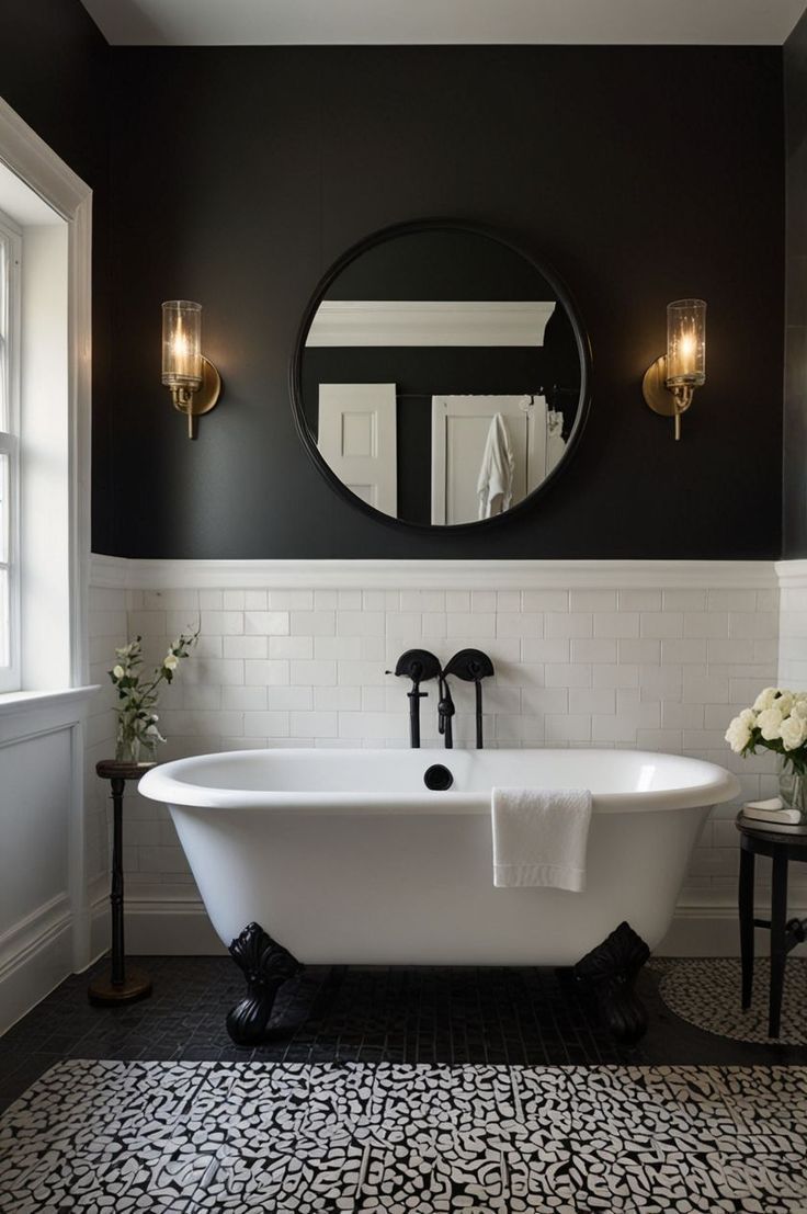 Monochrome bathroom with white solid-surface claw-foot bathtub on black lion feet, matte-black wall-mount faucet, half-height white subway tiles, charcoal walls, round black mirror and brass-glass sconces.