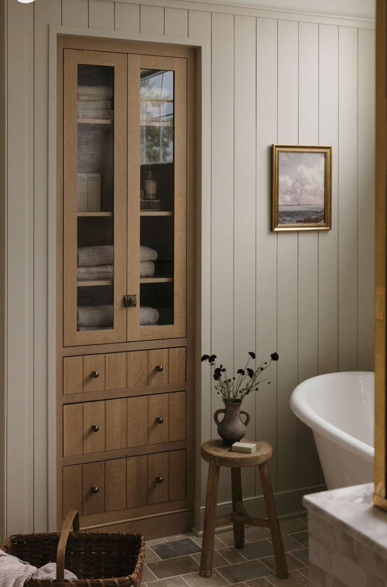 Natural style bathroom design featuring a solid wood storage cabinet and solid surface bathtub