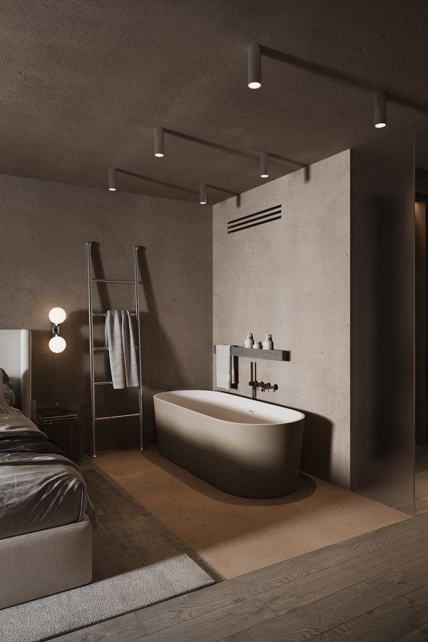Modern minimalist style freestanding oval bathtub in light beige, situated in an open-plan bedroom and bathroom space.
