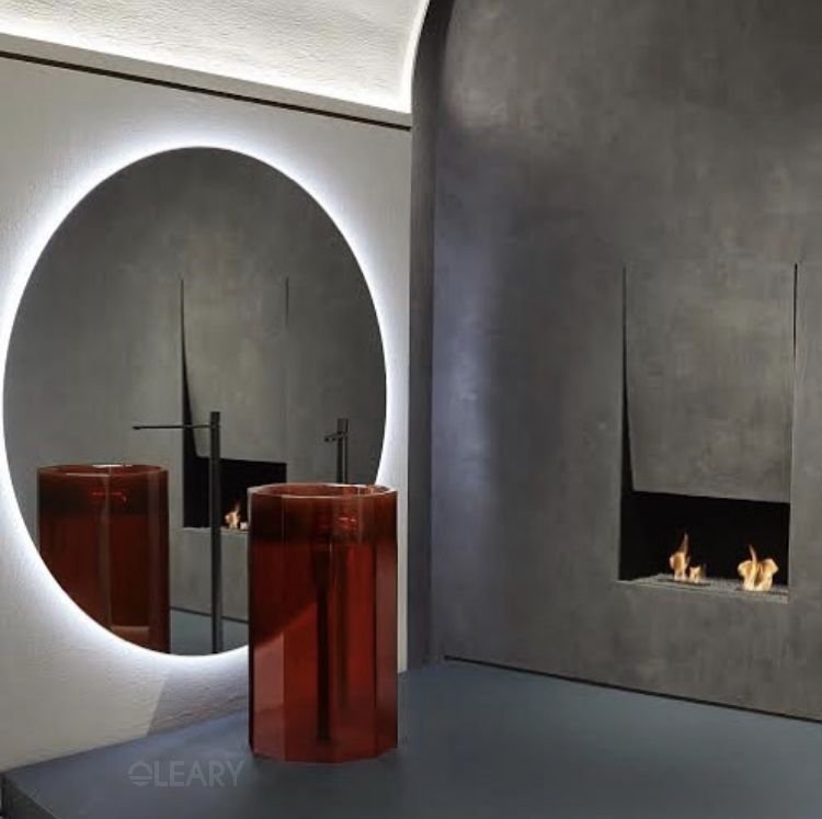 A modern bathroom featuring a sleek, black floating vanity with a wood accent, set against a backdrop of large format, grey marble-effect porcelain tiles.