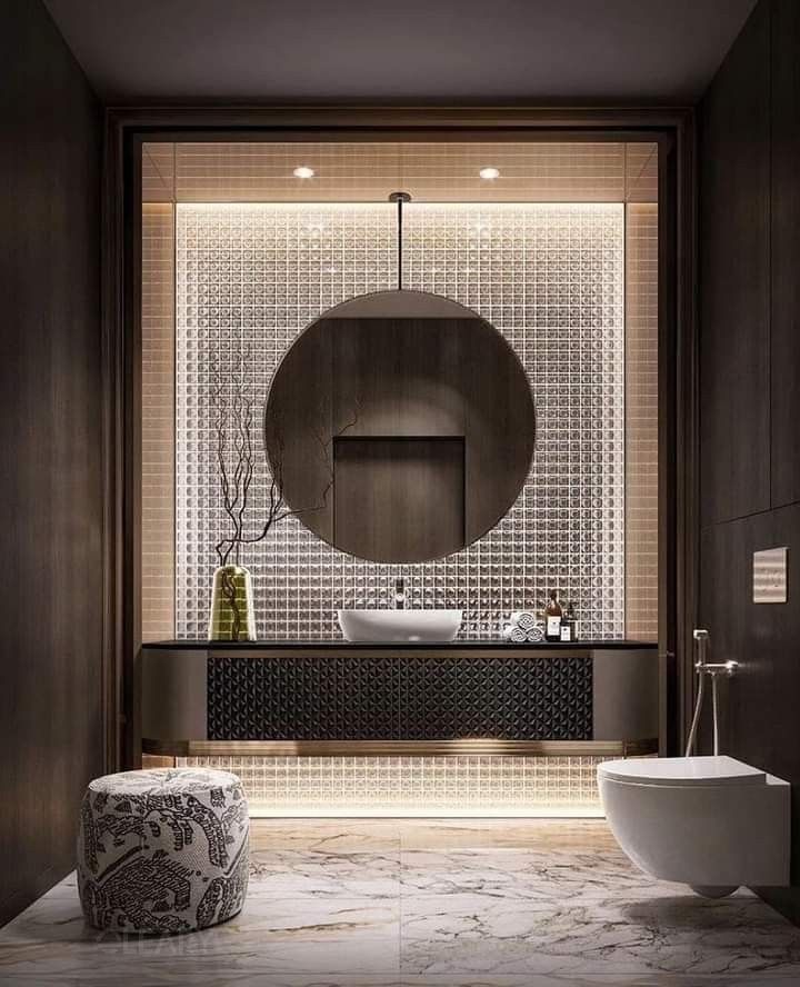 Luxurious modern powder room featuring a dark floating vanity with textured cabinet doors, a large suspended round mirror, and a backlit glass mosaic tiled accent wall.