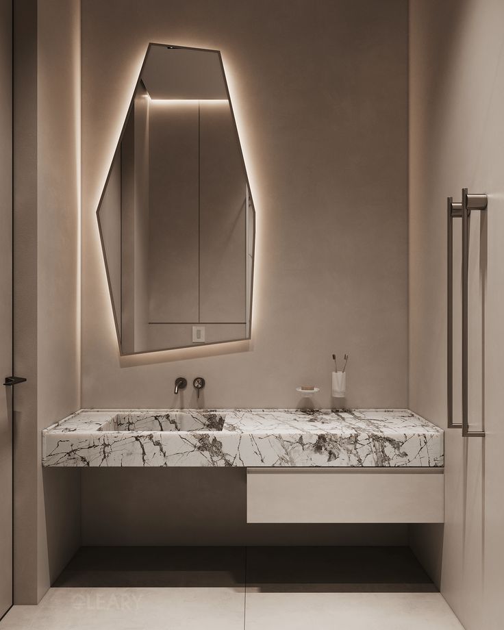 Modern bathroom featuring a white marble integrated basin and countertop with unique grey veining, illuminated by an irregular shaped LED backlit mirror.