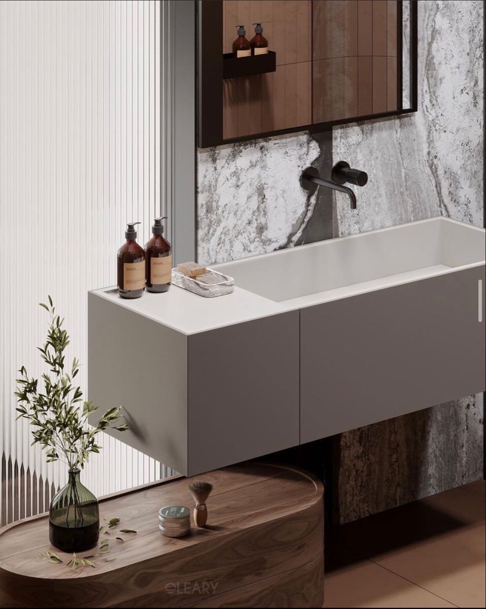 Modern floating grey bathroom vanity with an integrated white sink, matte black wall-mounted faucet, against a grey marble-look and white fluted accent wall.